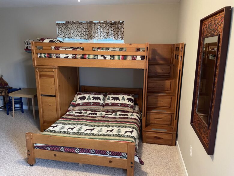 The Downstairs Bunk and Queen Room: a twin-over-full bunk reached by stairs, not a ladder, beside a queen bed