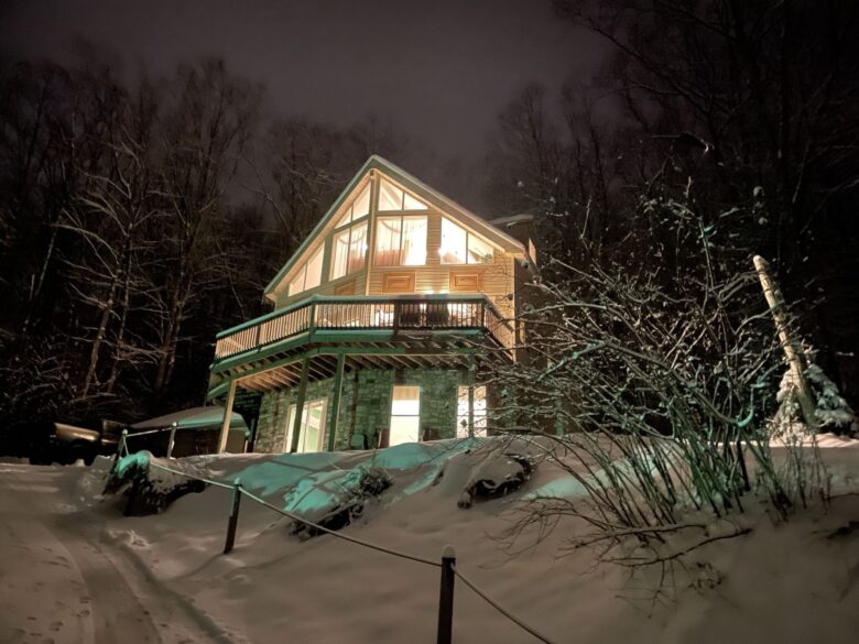 The chalet lit up at night in the snow