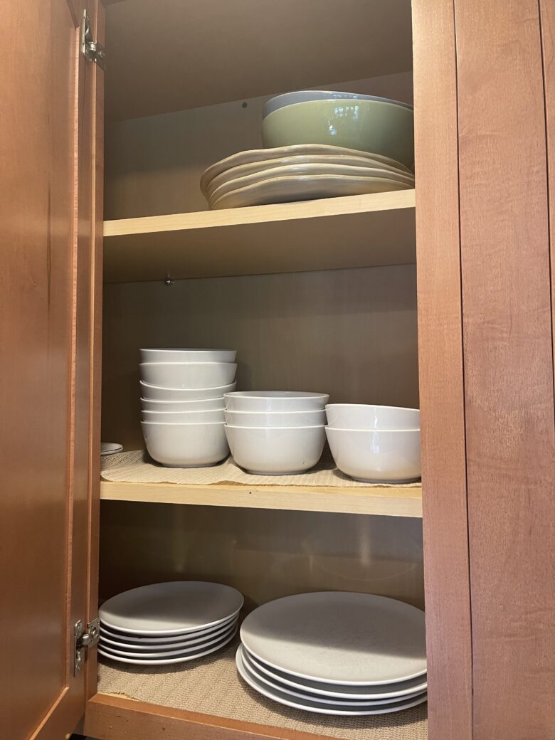 A kitchen cabinet of plates, bowls and serving dishes