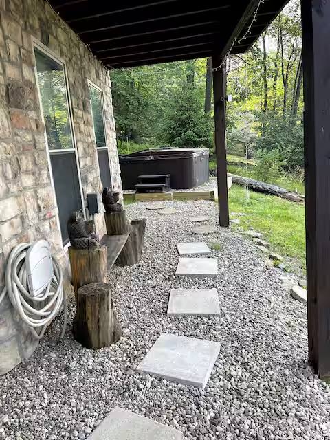 The covered patio under the deck, with the hot tub at the back
