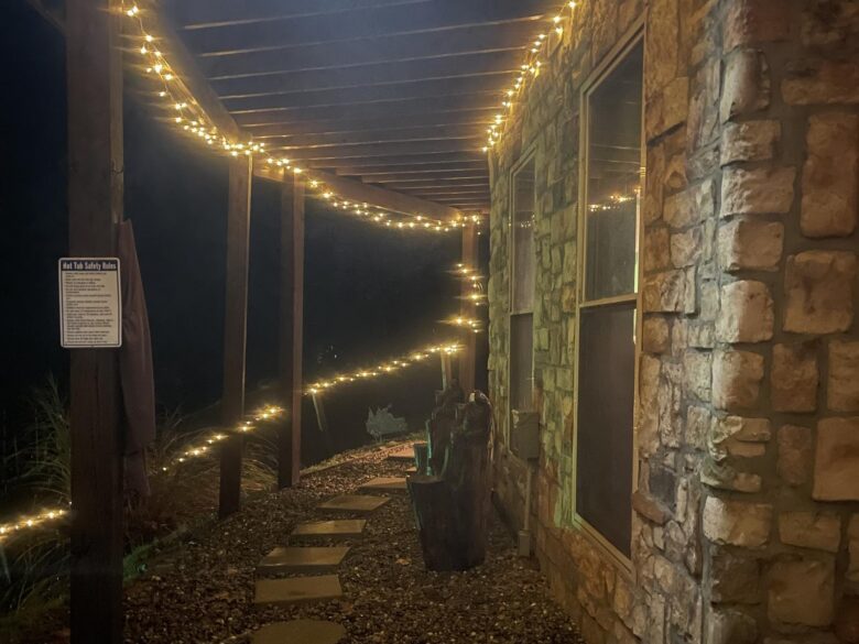 The lit stepping-stone path along the stone wall to the hot tub